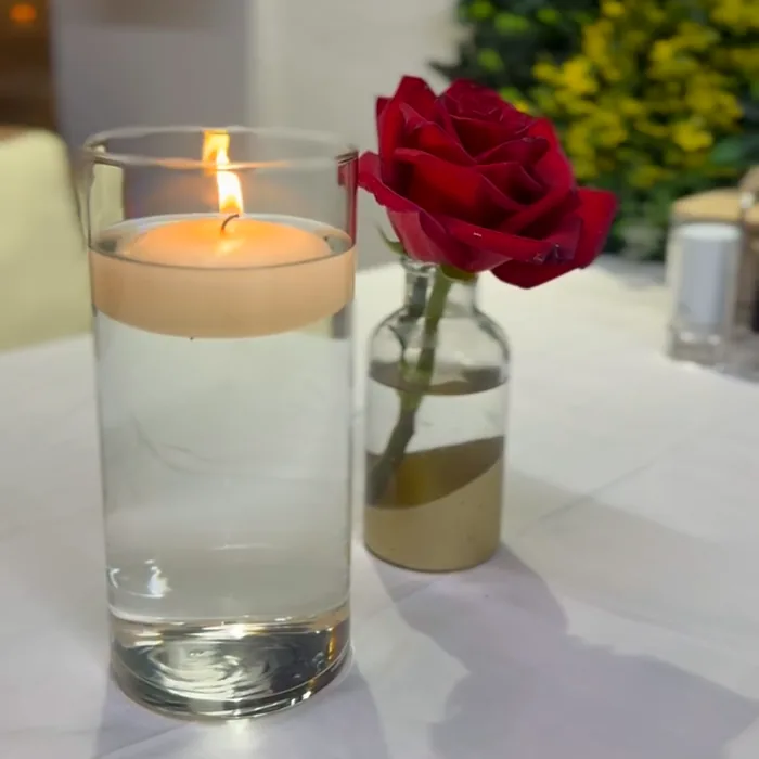 A candle burning on a table in the evening