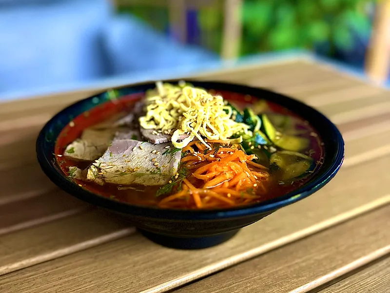 A chilled noodle bowl with vegetables and herbs