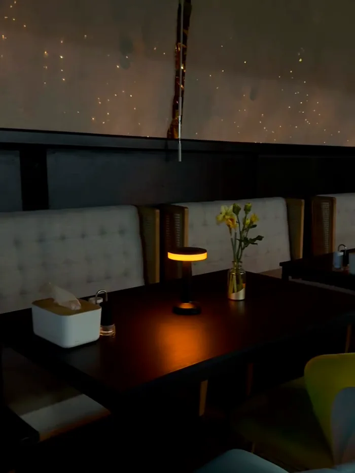 The dining room at Aurora in the evening, lit by table lamps