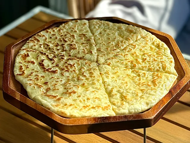 Chudu with cottage cheese, cut into wedges on a board