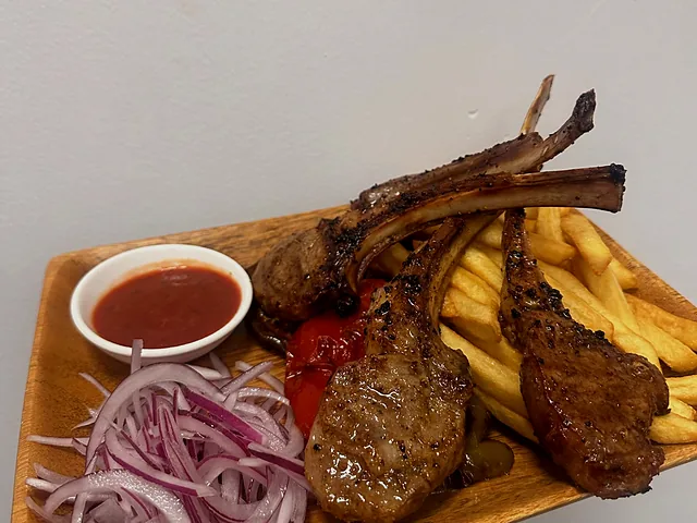 Lamb chops served with french fries and pickled onion