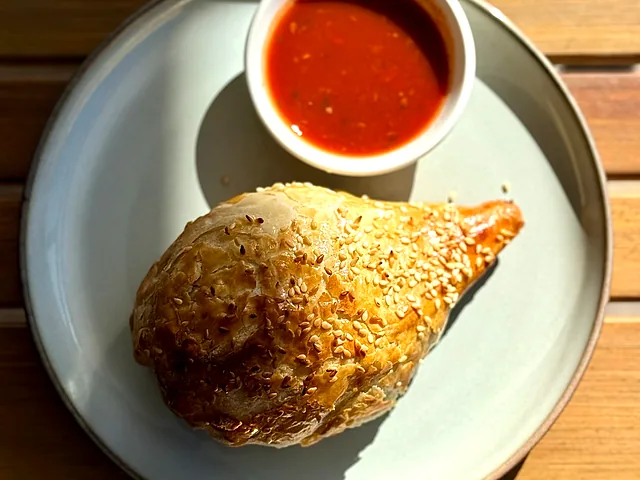 Samsa with sesame seeds served with a dipping sauce
